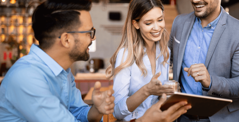 Great employees - three hsopitality workers smiling at a digital tablet