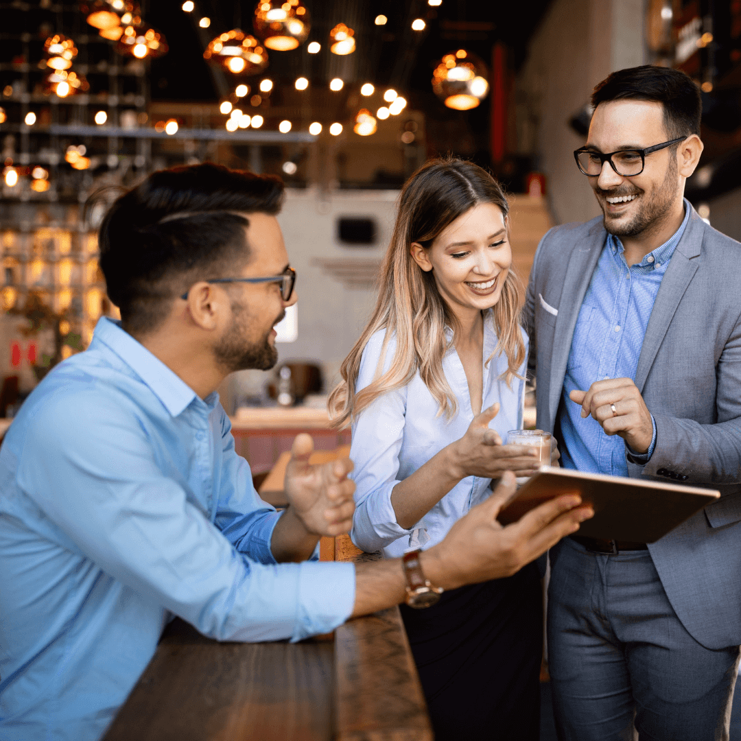 Great employees - three hsopitality workers smiling at a digital tablet