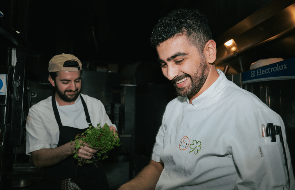 Two chefs smiling in a professional kitchen