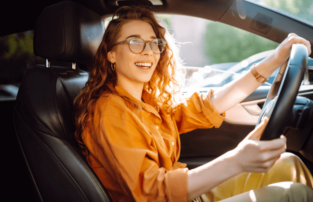 a happy woman driving a car