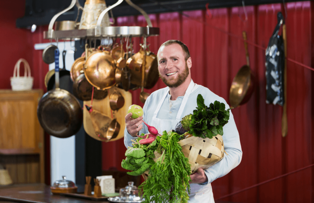 Leadership Skills: A happy chef holding a box of vegetables