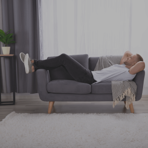 Leadership Skills: Man relaxing on a grey sofa