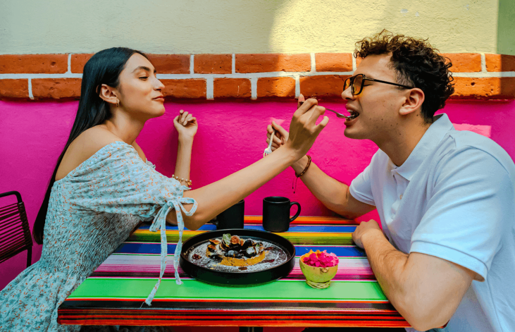 How to Handle Customer Complaints: A happy couple feeding each other at a restaurant