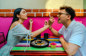 How to Handle Customer Complaints: A happy couple feeding each other at a restaurant