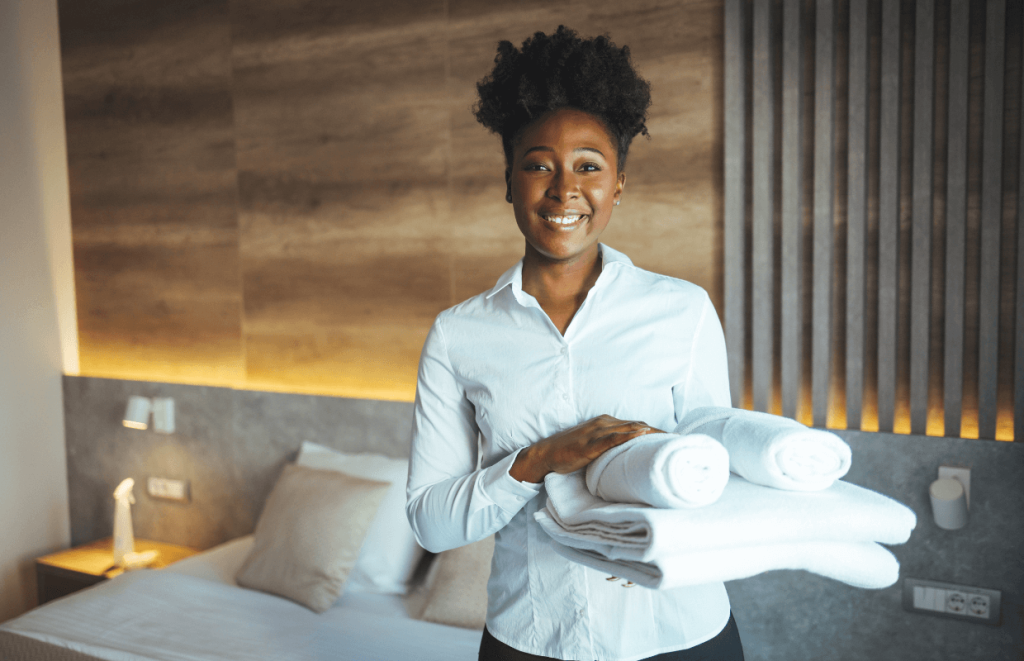 How to Handle Customer Complaints: Housekeeper smiling with folded towels in her hand