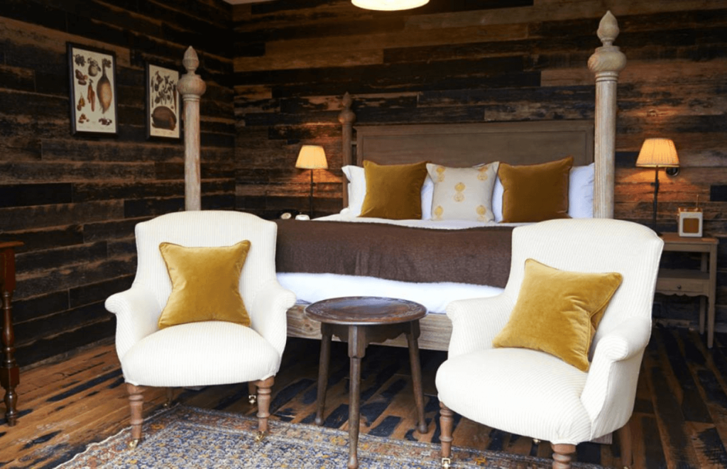 Modern four poster bed and two armchairs