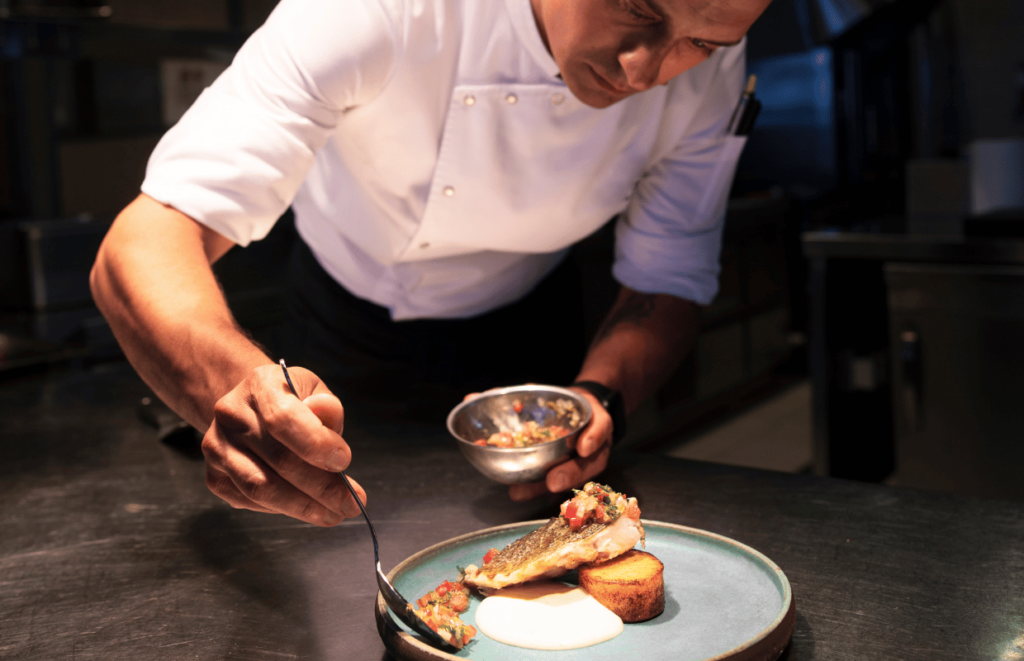 Elite staffing image showing a chef plating a dish