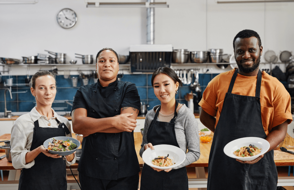 Team of chefs holding plates of their food
