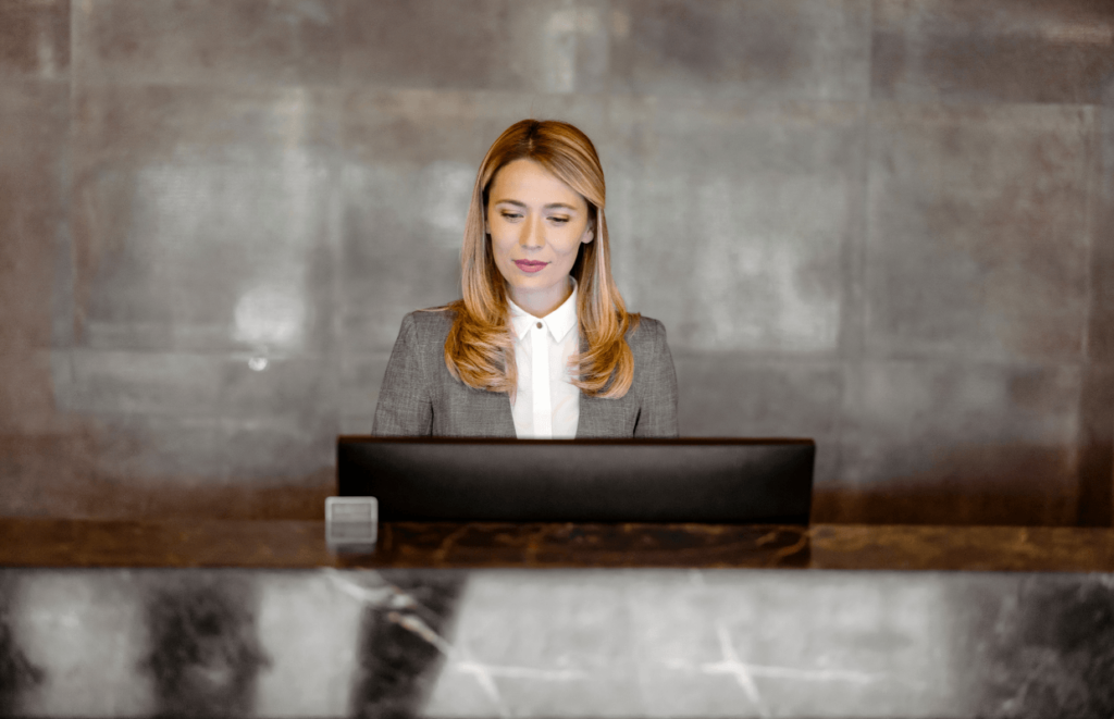 Hotel Receptionist looking down at a computer screen