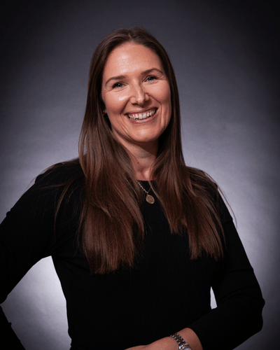 Portrait photo of Hollie Harket-Burgess smiling at the camera, wearing a black top